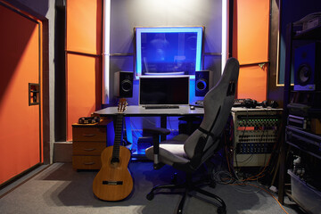 A sound engineer's workplace in a recording studio with a computer and an armchair