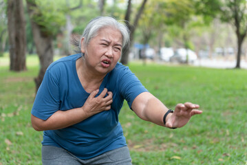 Naklejka na ściany i meble Elderly people have difficulty breathing and have chest pain from heart disease. While walking and exercising outdoors in the park Health care concept