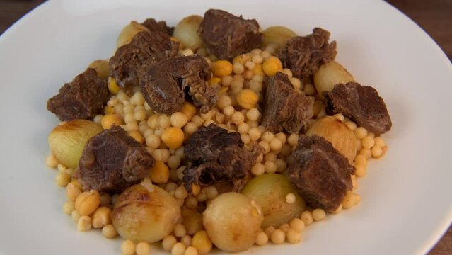 Moughrabieh is a popular dish in the Lebanese cuisine, LEBANESE RECIPE FOR MOUGHRABIEH WITH BEEF AND SMALL ONIONS, SEMOLINA PEARLS AND CHICKPEAS. High quality video