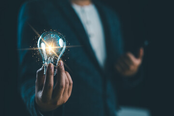 Hand of businessman holding illuminated light bulb with network connection line, idea, innovation...