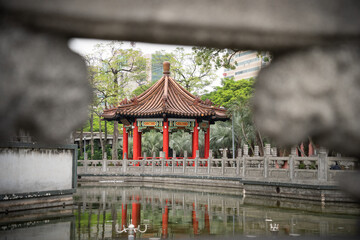 Traditional Chinese building in a city park framed by a concrete balustrade, Taipei, Taiwan