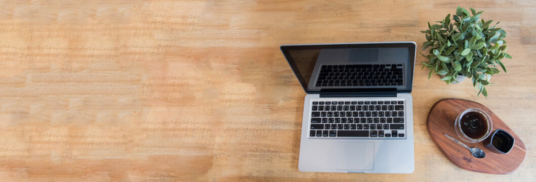 Banner Top view office desk laptop and coffee cup on wood table copy space.  Panorama tabletop notebook laptop coffee cup for officer display empty space wooden background workspace full banner design
