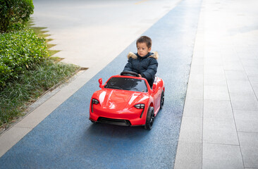 Adventurous Toddler Drives Red Sports Car with Joyful Glee