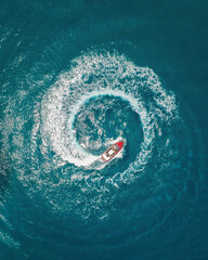 Aerial photography of a boat creating circle with a wake in the sea close to Crete island in Greece...