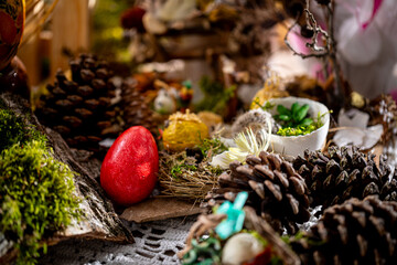 Rustic Easter Composition: Handcrafted Red Egg Amidst Natural Elements, Illuminated by Soft Light, Perfect for Festive Holiday Designs and Religious Celebrations
