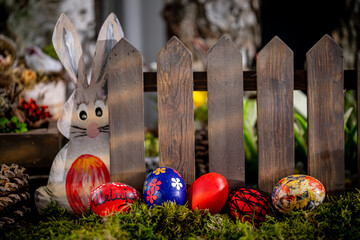 Whimsical Easter Scene: Handcrafted Eggs, Cute Bunny Cutout, and Rustic Fence - obrazy, fototapety, plakaty