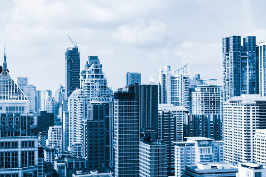 Closeup image of Bangkok cityscape. Modern skyscrapers with monochrome blue filter. Modern architectural building skyline with blue sky. Side view. Business background. Day light. Ornamented.