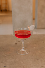 Red fresh cocktail in transparent glass on table isolated on background