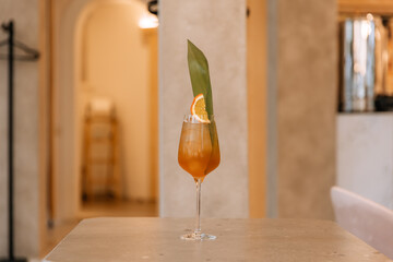 asian fizz cocktail with citrus and palm leaves on table in restaurant isolated on background