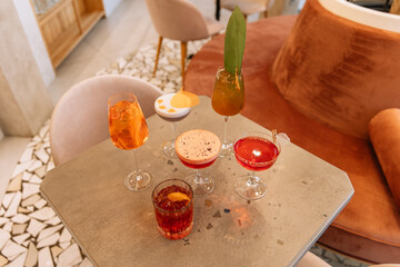 A set of cocktails on the table. Assortment of red, pink, white and orange alcoholic drinks in...
