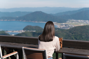 展望台テラスから風景を眺める美しいヘアカラーの女性
