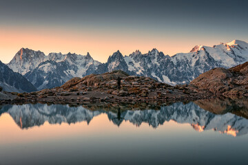 Lac Blanc with Mont Blanc mountain range and male tourist reflect on the lake in French Alps at...