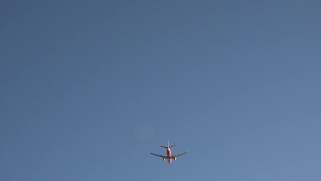 Orange plane departure take off flight on blue sky