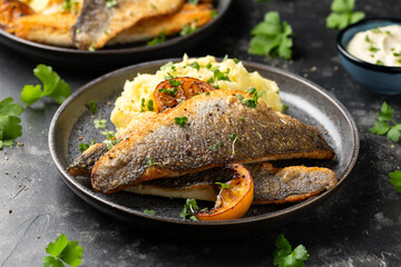 Pan fried sea bass fillets served with mashed potatoes and caramelised lemon