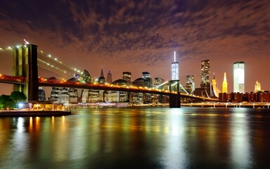 Panorama of downtown Manhattan and the Brooklyn bridge at night from Brooklyn in NYC - obrazy, fototapety, plakaty