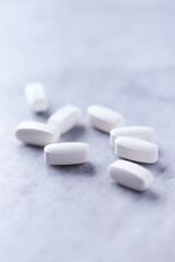 Lysine tablets. Concept for a healthy dietary supplementation. Nervous System Support. Bright stone background. Close up.	