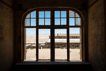 Aged, dilapidated room with a big window in an old desert town