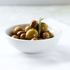 Various olives on white wooden background. Close up. Copy space