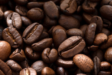 Brown roasted coffee beans on dark background. Espresso dark, aroma, black caffeine drink.