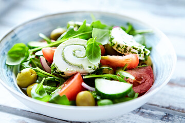 Summer Salad with Cream Cheese, green Olives, Tomatoes and fresh Basil. Bright wooden background....