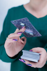 Female hands holding tarot cards for fortune telling and tricks