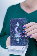 Female hands holding tarot cards for fortune telling and tricks