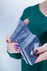 Female hands holding tarot cards for fortune telling and tricks