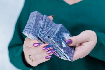 Female hands holding tarot cards for fortune telling and tricks