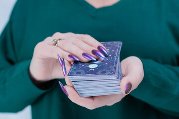 Female hands holding tarot cards for fortune telling and tricks