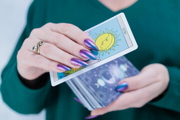 Female hands holding tarot cards for fortune telling and tricks