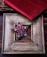Christmas ornament in the shape of a star on a vintage wooden background. Soft focus. Copy space.