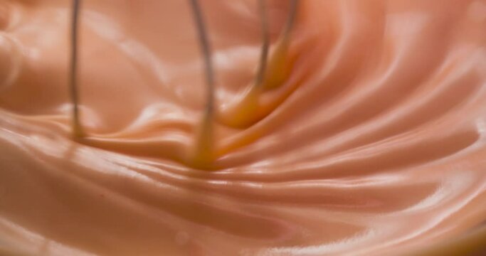 Whipping the orange icing with a large whisk.
