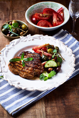 Grilled pork steak with fresh salad. Close up.