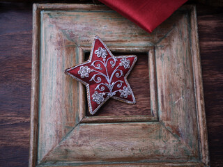 Christmas ornament in the shape of a star on a vintage wooden background. Soft focus. Copy space.
