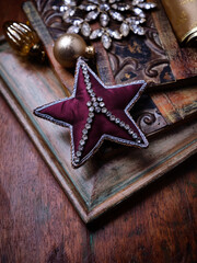 Christmas ornament in the shape of a star on a vintage wooden background. Soft focus. Copy space.
