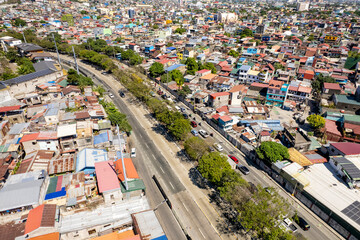 Taguig, Metro Manila, Philippines - Feb 03, 2024: Aerial view of C5 road cutting through a dense...