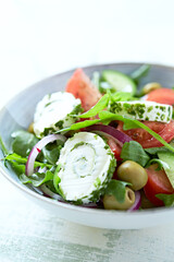Summer Salad with Cream Cheese, green Olives, Tomatoes and fresh Basil. Bright wooden background. Close up	