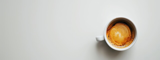 A close-up shot featuring a white coffee cup filled with coffee, set against a pristine white background, evoking simplicity and elegance.