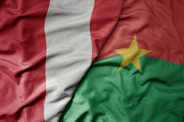 big waving national colorful flag of burkina faso and national flag of peru .