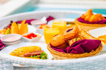 served floating tray in swimming pool with drinks and snacks on tropical island resort in Maldives, breakfast for romantic date or honeymoon in luxury hotel, travel concept