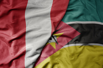 Fototapeta premium big waving national colorful flag of mozambique and national flag of peru .
