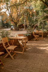 a quiet outdoor cafe with wooden tables on an autumn street. a quiet outdoor cafe with wooden tables on an autumn street. an empty street cafe in autumn.