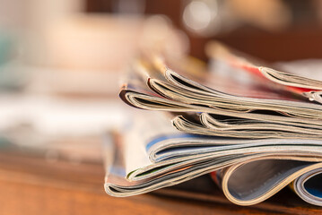 Pile of old newspapers magazines on toned blur background - obrazy, fototapety, plakaty