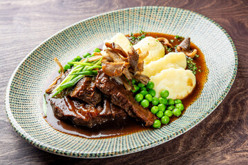 Stewed beef veal cheeks with mashed potatoes on plate