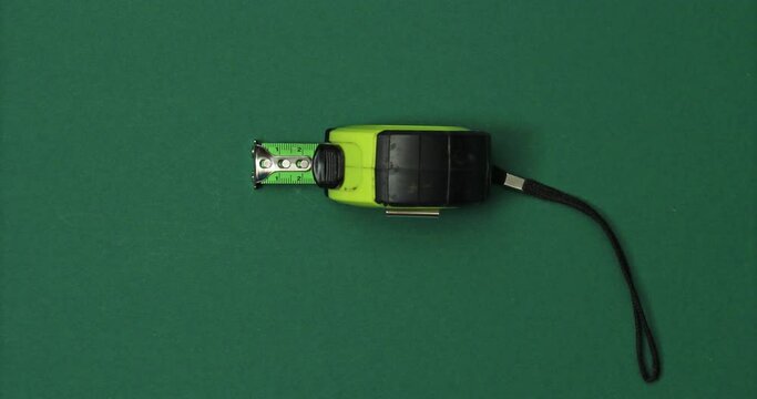 Tape measure. Tools in action on color background. Loopable stop motion animation. 4K top view. DIY video concept