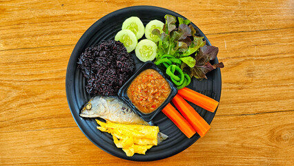 Riceberry rice served with mackerel chili paste and vegetables on the side, Thai style food