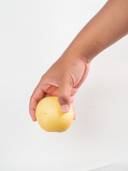 A pear is held in a hand with a white background