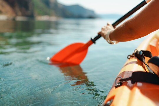 Kayak paddle sea vacation. Person paddles with orange paddle oar on kayak in sea. Leisure active lifestyle recreation activity rest tourism travel