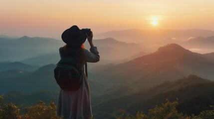 Woman taking photos at sunset in the mountains - Powered by Adobe