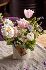 a beautiful delicate spring bouquet of tulips, buttercups and muscari, floral arrangement